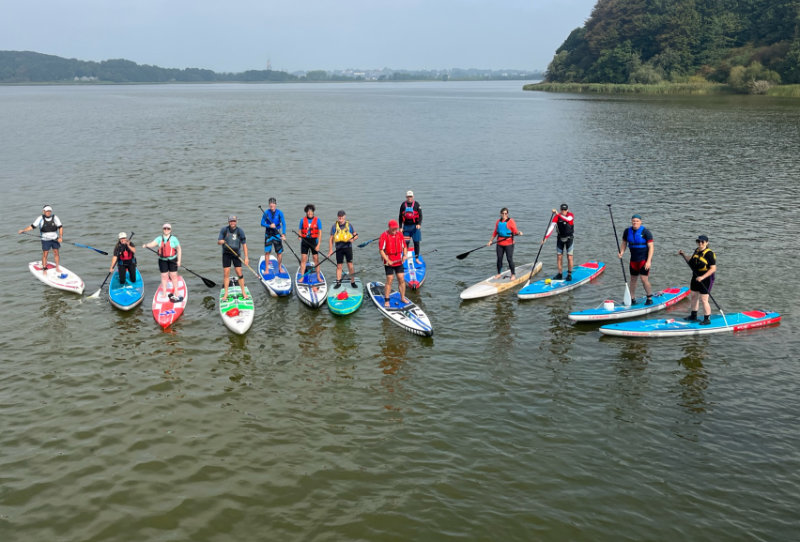 SUP Ausbildung: Gruppenbild von schräg oben von allen Teilnehmenden auf dem Wasser<br />